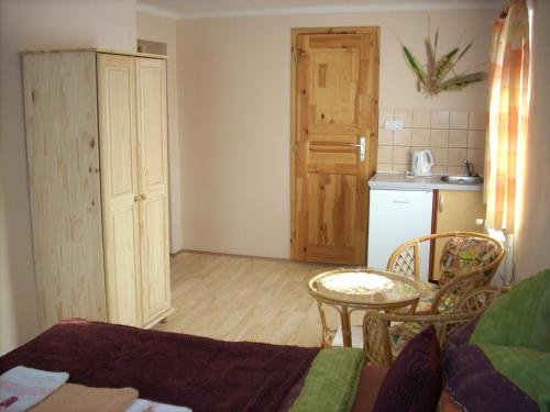 a living room with a table and a kitchen at Penzion U Račáku in Frymburk