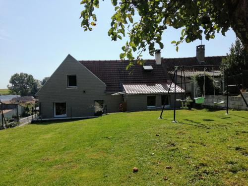 ein Haus mit einem Hof mit Schaukel in der Unterkunft Le chant des grenouilles in Boismont