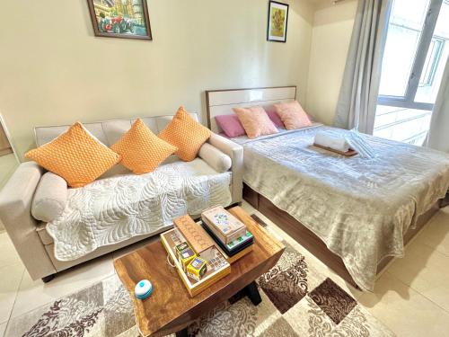 a living room with a bed and a couch at Condo Unit inside IT Park Lahug Cebu City in Cebu City