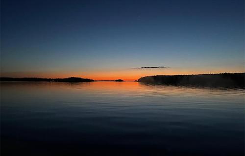 a large body of water with a sunset in the background at Gorgeous Home In Ljusterö in Norra Ljustero