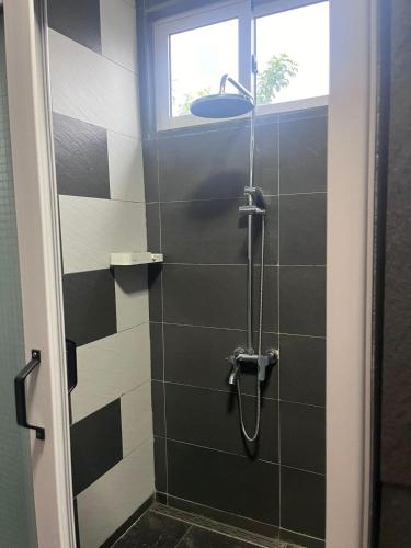 a bathroom with a shower with black and white tiles at Blue IV residence in Mauritius