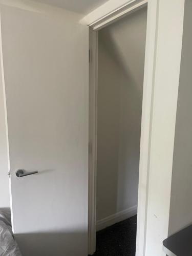 a white closet with a sliding door in a room at ComfortVilla LR in Hornchurch