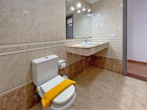 a bathroom with a toilet and a sink and a mirror at Villa Charlotte in Tías