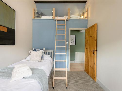 a room with a bunk bed and a ladder at Lantern Lodge in Bramley