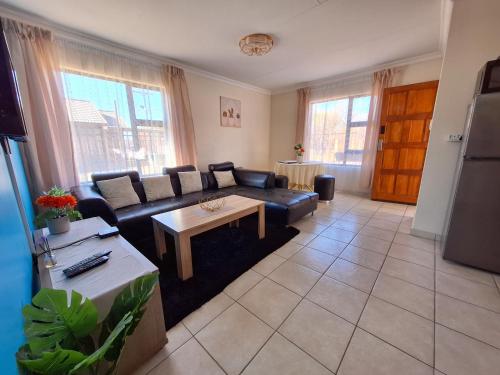 a living room with a couch and a table at MV self-catering 3 Units in Bloemfontein