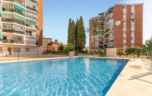 a large swimming pool with buildings in the background at 1 Bedroom Cozy Apartment In Torremolinos in Torremolinos