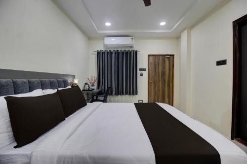 a bedroom with a black and white bed and a door at Super Hotel O EMBASSYINN in Kondapur