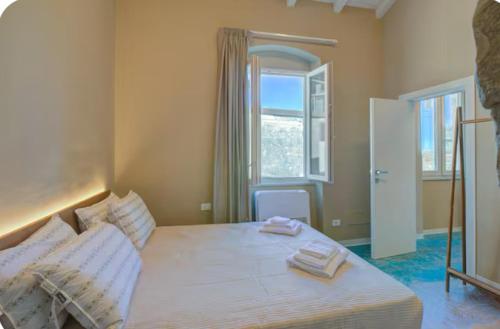 a bedroom with a bed with two towels on it at Emozione Blu in Monte Marcello