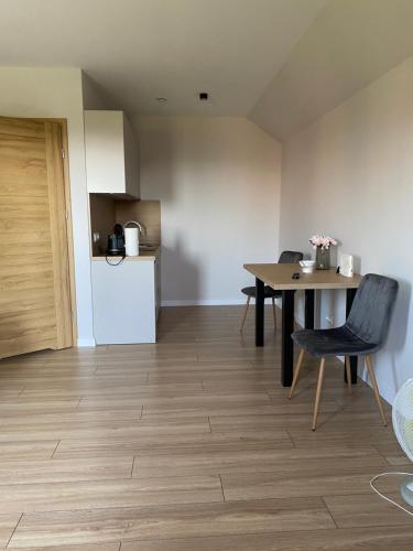 a kitchen and dining room with a table and a refrigerator at Widokówka Radostowa 