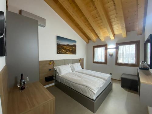 a bedroom with a bed and a table in it at Agrialloggio Cantina Piccolin in Valdobbiadene