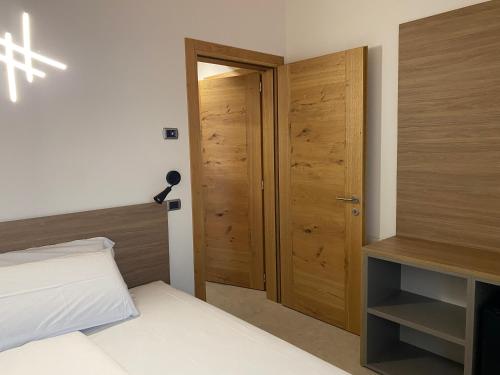 a room with a bed and a wooden door at Agrialloggio Cantina Piccolin in Valdobbiadene