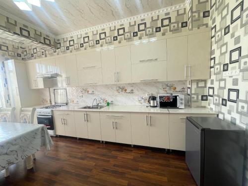 サマルカンドにあるluxury apartments 6の白いキャビネットとカウンタートップを備えたキッチン