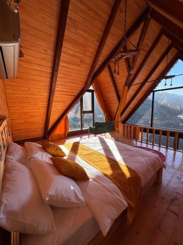 a bed in a room with a large window at Seyrona Butik Otel in Çamlıhemşin