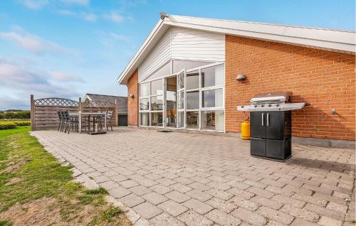 a brick house with a patio and a grill at Beautiful Home In Faaborg With Sauna in Fåborg