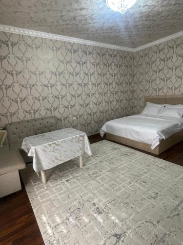 サマルカンドにあるluxury apartments 6のベッドとソファとテーブルのある寝室