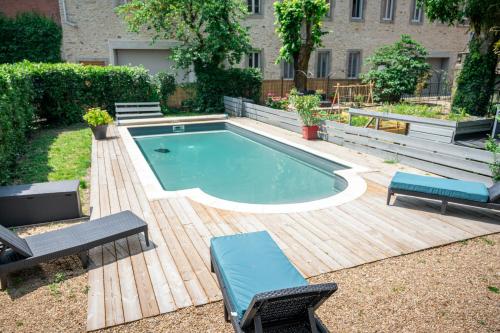 a swimming pool with two chairs and a table at La Grande Maison Mazamet in Mazamet