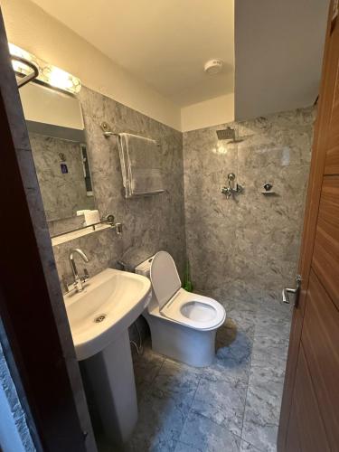 a bathroom with a toilet and a sink at hidden courtyard nayalakhu in Pātan
