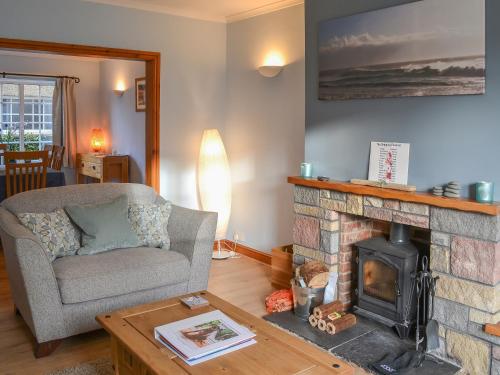 a living room with a couch and a fireplace at Bramble Cottage in Craster