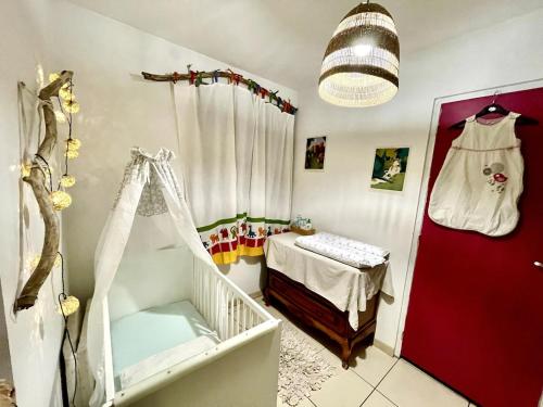 una camera per bambini con una culla e una camera con di Au moulin maison familiale a La Broque