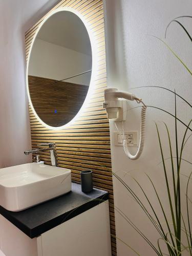 a bathroom with a sink and a mirror at Neva Apartments & Rooms in Făgăraş