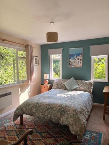 a bedroom with a bed and two windows at B&B Higher Quantock in Stockland