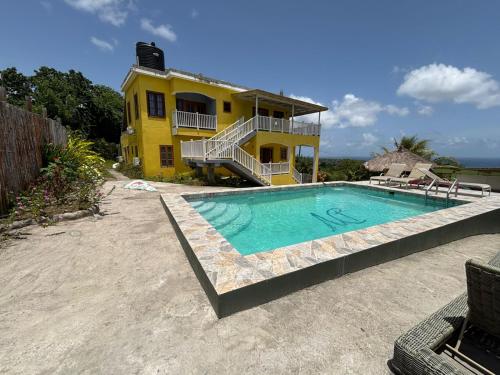 a house with a swimming pool in front of a house at Desired View in Choiseul