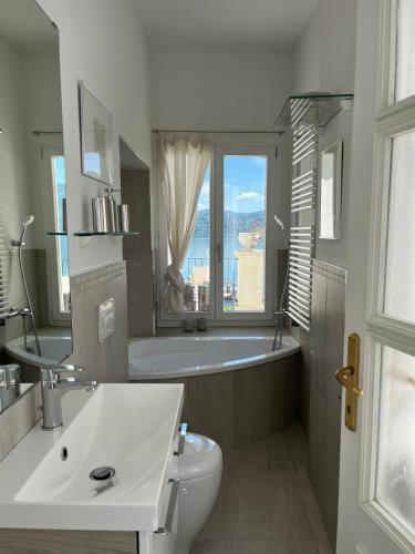 a bathroom with a tub and a toilet and a sink at Schwalbenhaus in Oggebbio