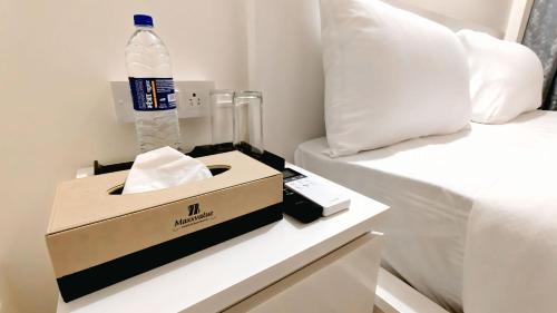 a bottle of water in a box next to a bed at Lake Side Serviced Apartment by Maxxvalue in Mumbai