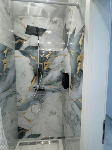 a shower in a bathroom with a marble wall at Downtown Apartment in Bonn