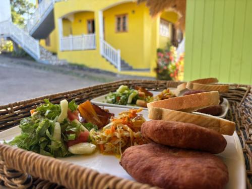 a plate of food on a table with a basket of food at Desired View in Choiseul