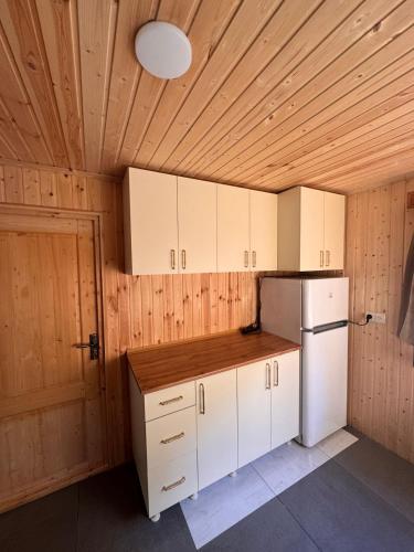 a kitchen with white cabinets and a white refrigerator at In the Forest in K'vemo Jocho