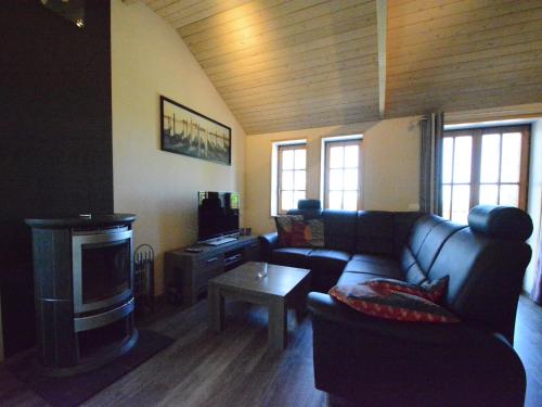 a living room with a couch and a tv at Charming Chalet in Vielsalm in Vielsalm