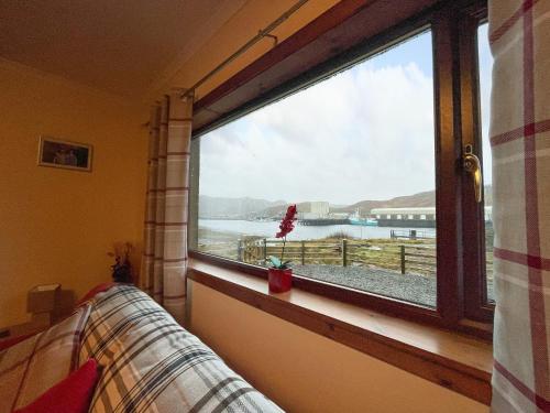 a window in a room with a view of the water at Bervie Road Cottage in Kinlochbervie