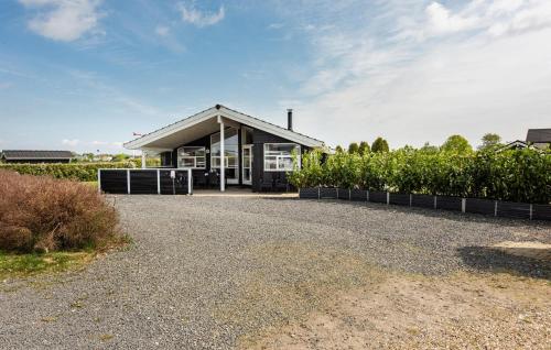 a house with a gravel driveway in front of a building at Holiday Home Chr Jacobsensvej in Årøsund