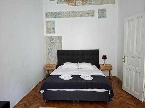 una camera da letto con un letto con due asciugamani sopra di Tiskara 1897 a Zagabria