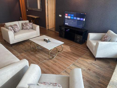 a living room with couches and a flat screen tv at Centaurus Ultra Luxury 2BHK Mountain Vista Apartment in Islamabad