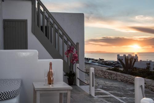 a balcony with a table and a bottle of wine at Christy Suites by Alpha Living in Mikonos