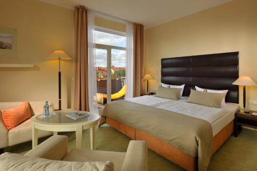 ein Hotelzimmer mit einem Bett und einem Tisch in der Unterkunft Resort Mark Brandenburg & Fontane Therme in Neuruppin