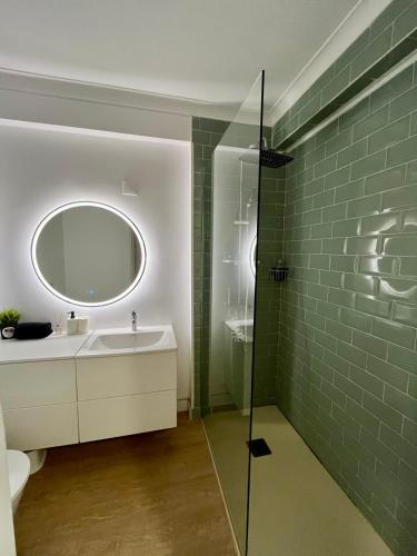 a bathroom with a sink and a mirror at Lisbon Beach Flat- Costa Caparica in Costa da Caparica
