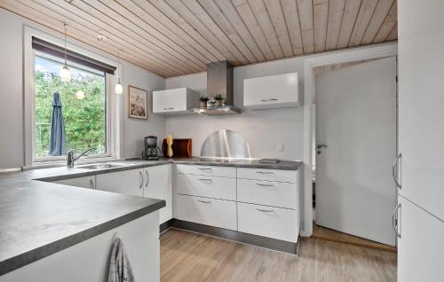 a kitchen with white cabinets and a wooden ceiling at Lovely Home In Ansager With Wifi in Ansager