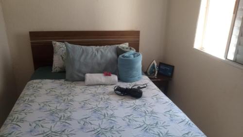 a bedroom with a bed with shoes and pillows at Cozy House Booking Indaiatuba in Indaiatuba