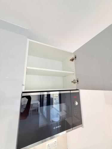 a kitchen with a black microwave and a table at E1 Simple Apartment in Gibraltar