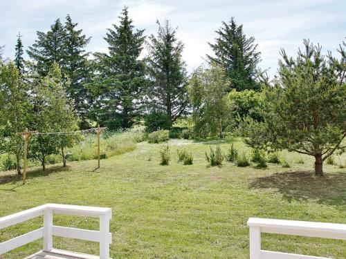 two white benches in a field with trees at 6 person holiday home in Fjerritslev-By Traum in Fjerritslev