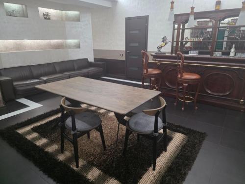 a living room with a wooden table and chairs at Casa Italiana with Exclusive Pool in Odesa