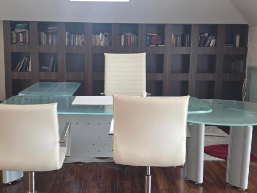 a dining room with a glass table and white chairs at Casa Italiana with Exclusive Pool in Odesa