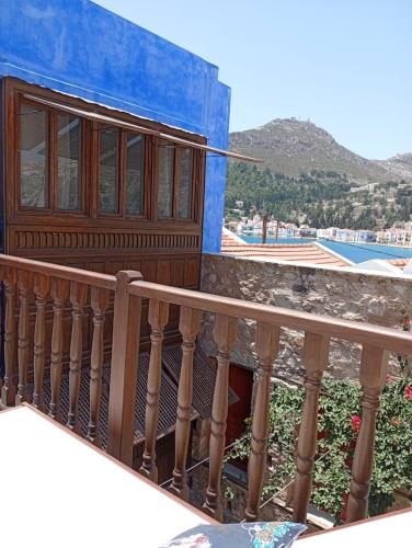 a balcony of a blue building with a wooden railing at Casa Muse Kastellorizo Whole House in Meyisti