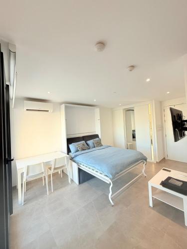 a bedroom with a bed and a table at E1 Simple Apartment in Gibraltar