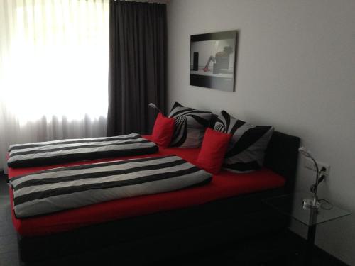 a bed with a red blanket and a window at Landhaus Goldenes Kreuz in Leutkirch im Allgäu