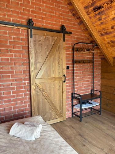 a brick wall with a door and a bed in a room at Stodoła na Drobnym Wierchu in Podwilk