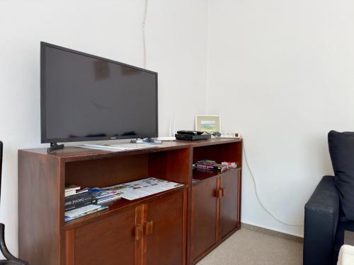 a flat screen tv on a wooden entertainment center at Privát Ruženka in Liptovský Mikuláš